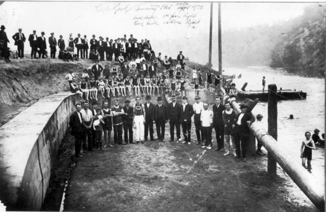 1918-1920 Deep Rock Swimming Club. Description: A large group of men and boys (many in bathing suits) posed at the Deep Rock swimming area above Dight's Falls