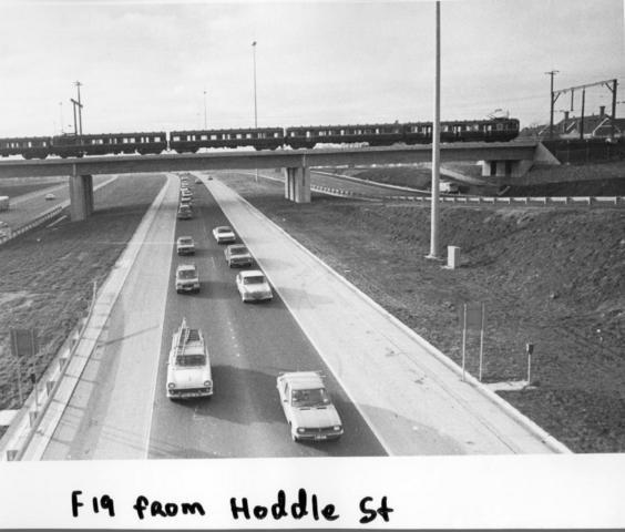 1970s The F19 freeway from Hoddle Street. Shows the freeway shortly after it was opened with a train crossing the railway bridge and Victoria Park school visible on the right.